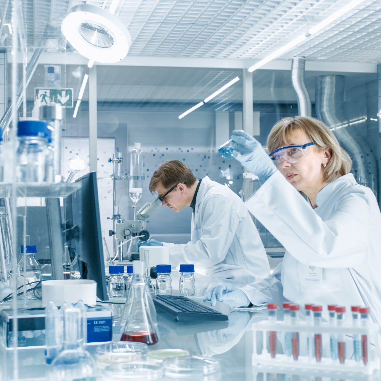 Female,Scientist,Analyzes,Liquid,In,The,Beaker,And,Types,Down